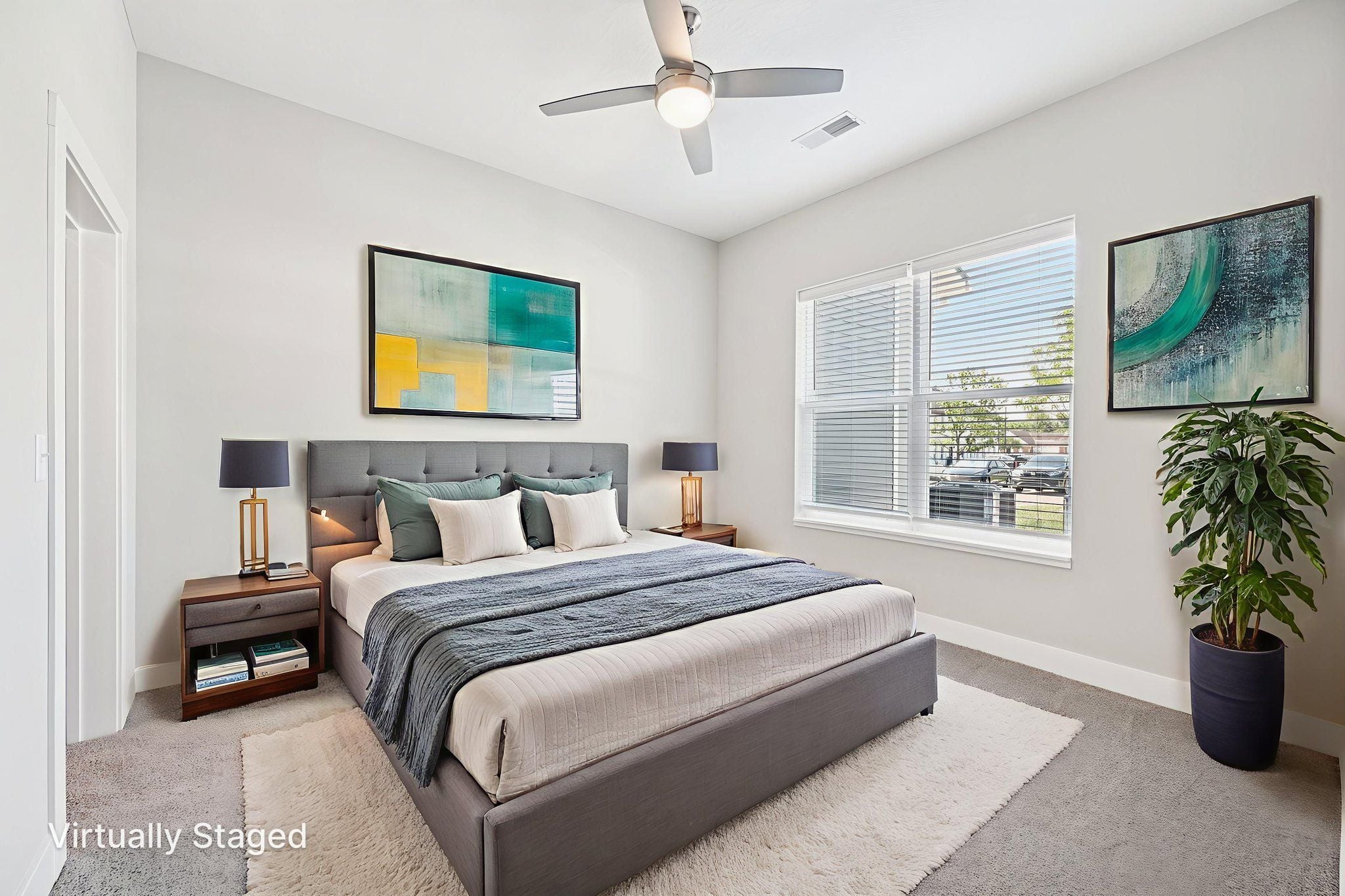 A bedroom with a large bed and a ceiling fan.
